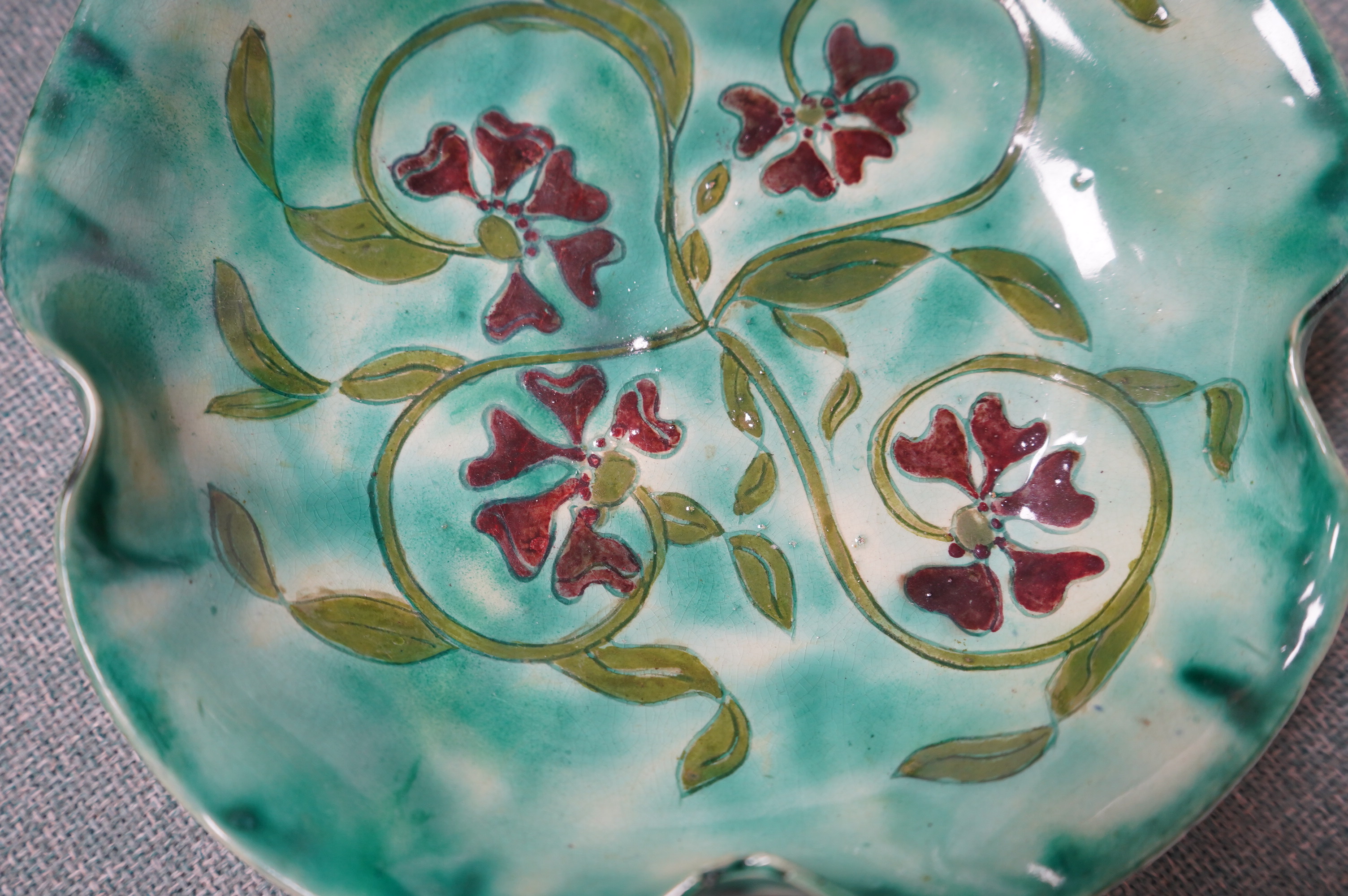 A Della Robbia green glazed floral dish, 19cm diameter. Condition - good.